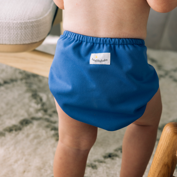 Child in a blue swim diaper on a blurred background