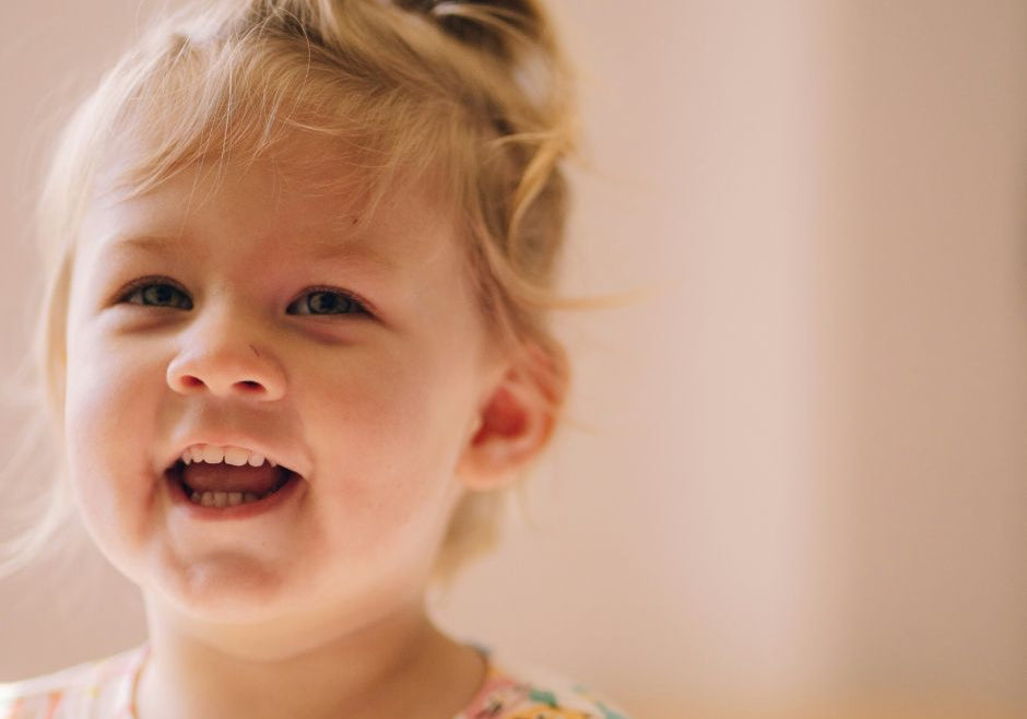 A toddler girl smiling.