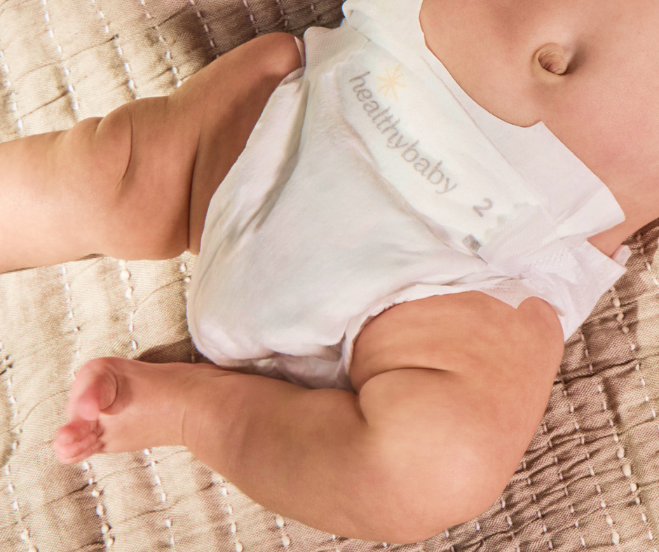 A close-up of a huge baby belly and legs wearing a HealthyBaby diaper.
