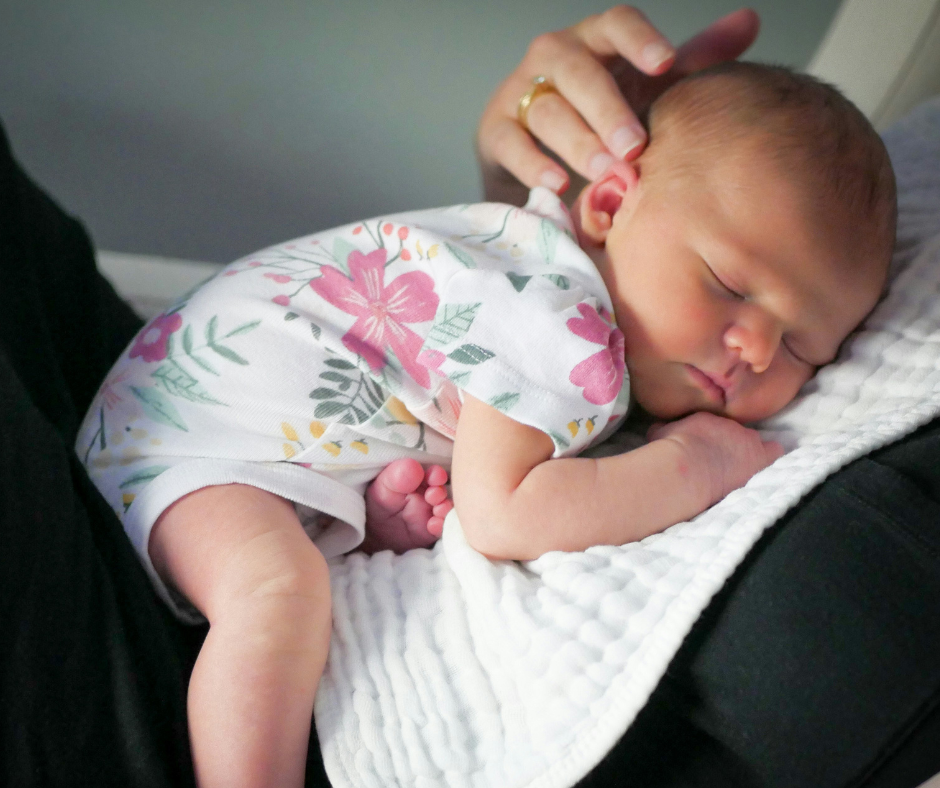 A baby girl naps on her mom's chest