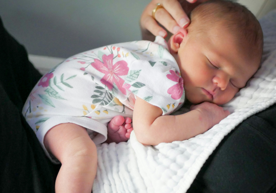 A baby girl naps on her mom's chest