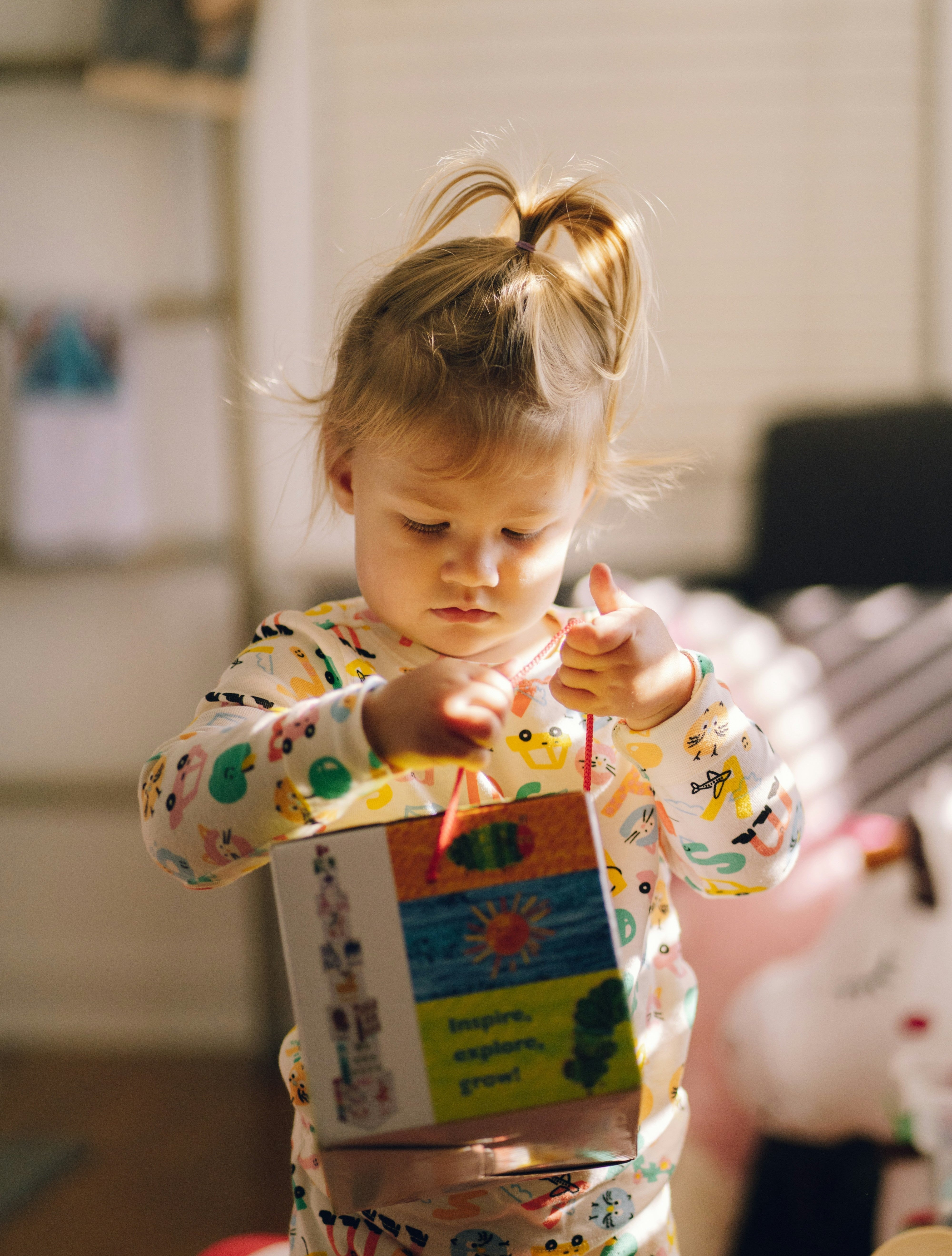 An adorable toddler girl playing with a book.